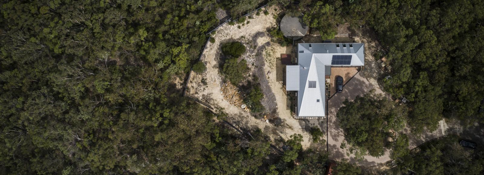 A photo of a home with a LYSAGHT® steel roof, surrounded by bushland