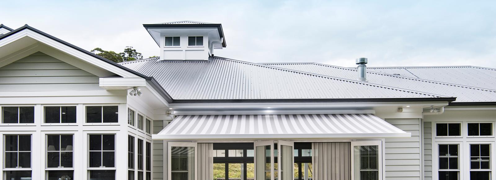 Hamptons style house with Lysaght CUSTOM ORB® roofing and light walls for a classic coastal look.
