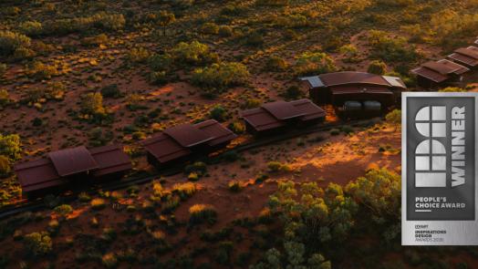 Aerial view of red-roofed eco-lodges across desert scrub at sunset, with People's Choice badge
