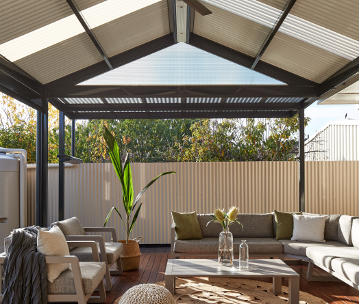 Interior view of a gable roof pergola made from COLORBOND® steel, featuring corrugated roof sheets and a ceiling fan.