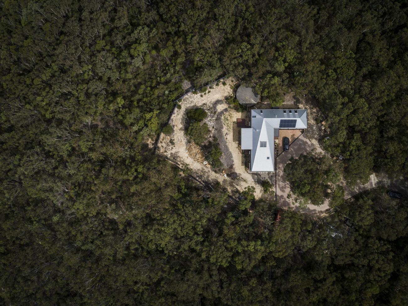 A photo of a home with a LYSAGHT® steel roof, surrounded by bushland