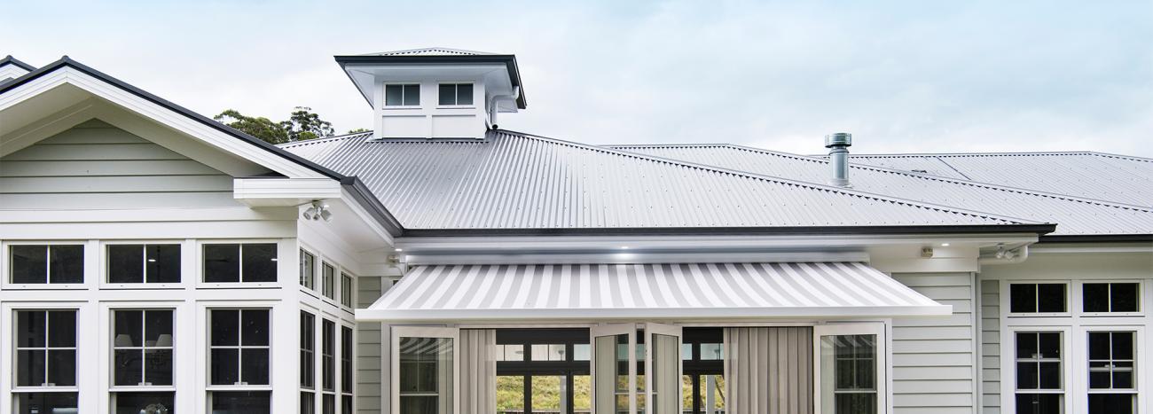 Hamptons style house with Lysaght CUSTOM ORB® roofing and light walls for a classic coastal look.